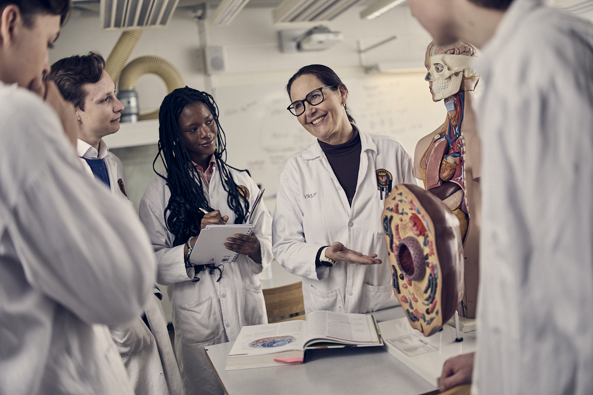 Lärare visar engagerat upp exempel under en biologi-lektion.