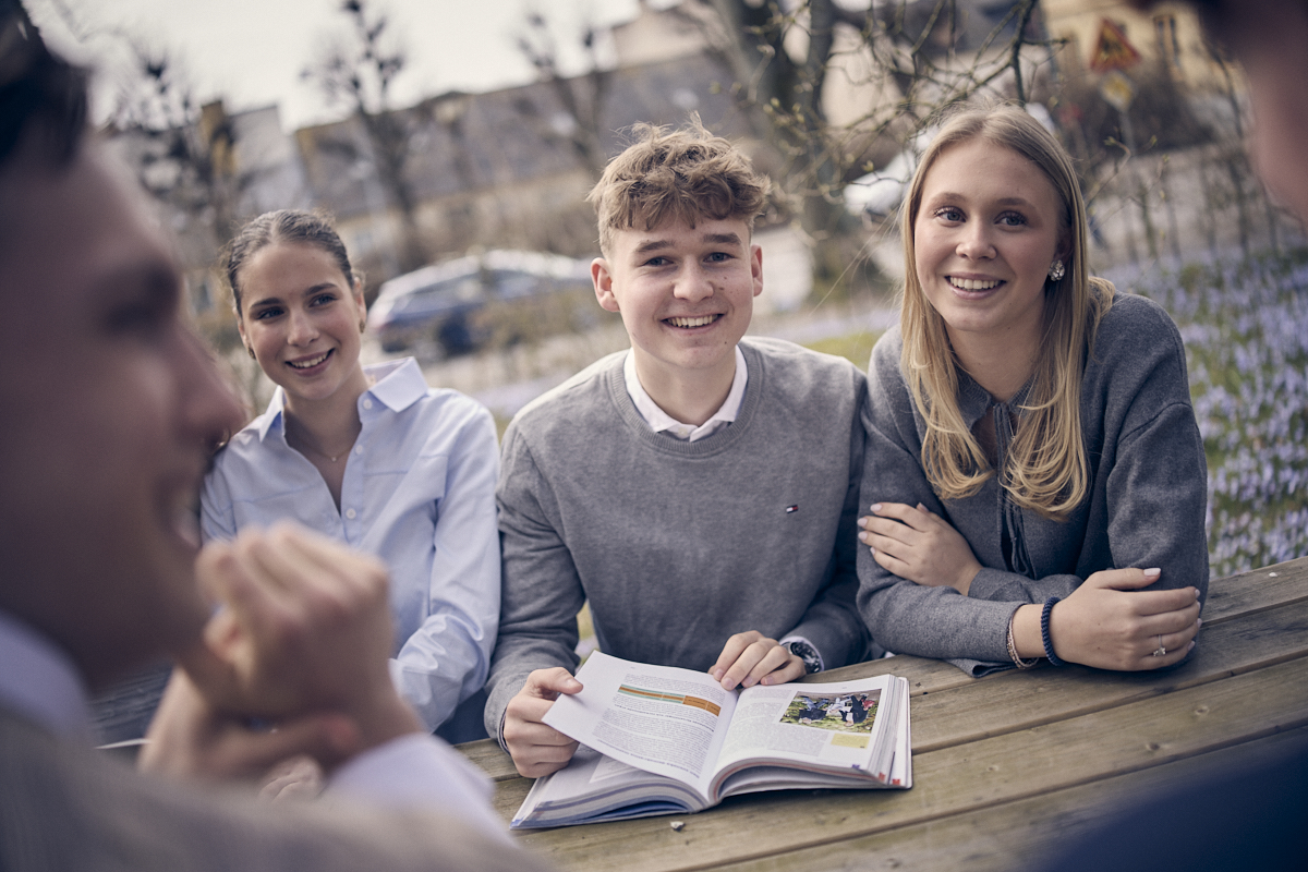 Elever sitter utomhus och pluggar.
