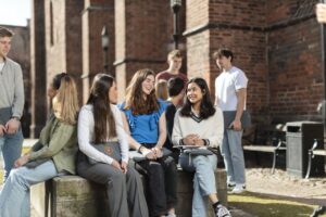 Elever sitter utanför skolan