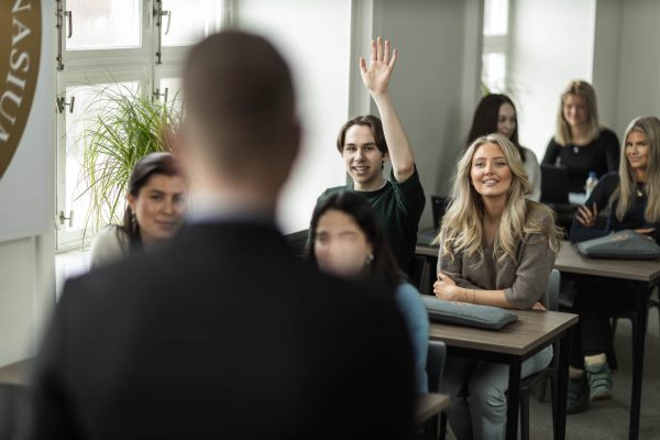 Elever i ett klassrum och en lärare i förgrunden