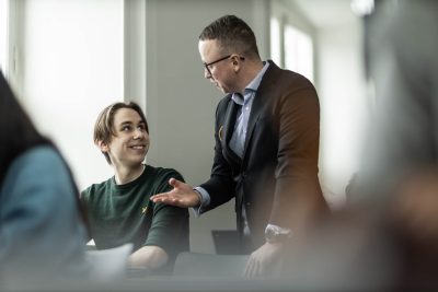 Elev och lärare diskuterar i ett klassrum