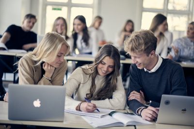 Elever sitter i en skolbänk och arbetar tillsammans