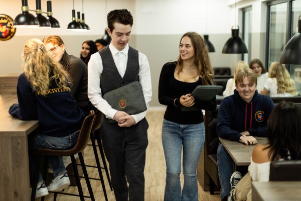 Två elever går i en skolkorridor