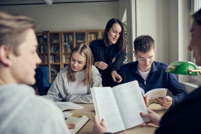 Elever och lärare i ett bibliotek