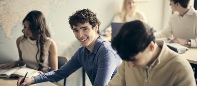 Glad elev i klassrummet som tittar in i kameran.