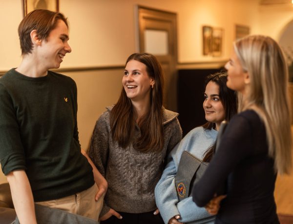 Elever står och pratar i en korridor