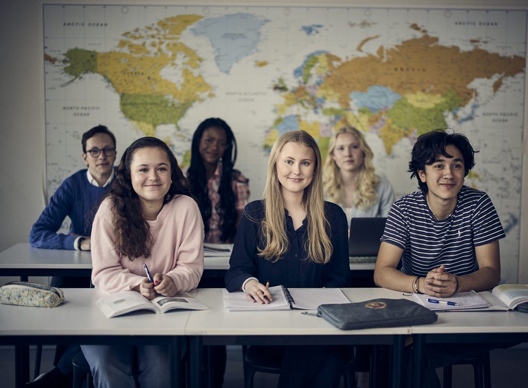Elever sitter på lektion och lyssnar intresserat.