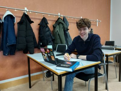 Alumnen Linus sitter vid en skolbänk vid Uppsala universitet