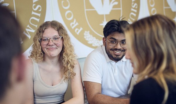 Elever hänger i skolans korridorer vid ett bord.