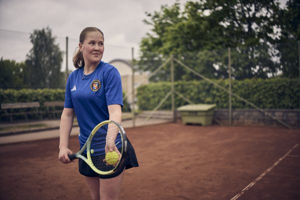 En tjej som ska slå ett tennisslag.
