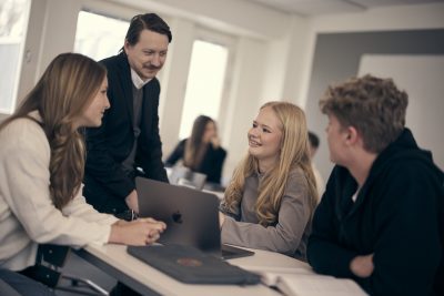 Elever pluggar tillsammans med sin lärare.